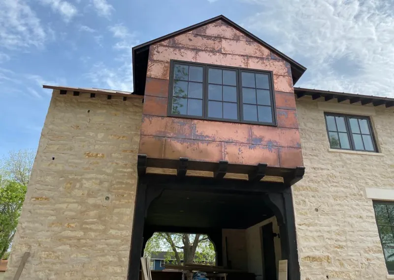 Copper metal panel facade on a stone building for Roof Repair in Butler