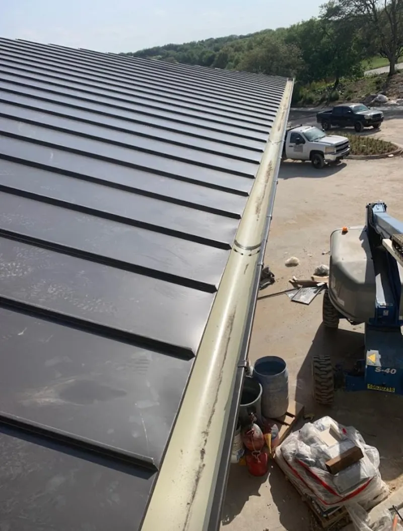 Standing seam panel and gutter detail on a metal roofing jobsite in Butler